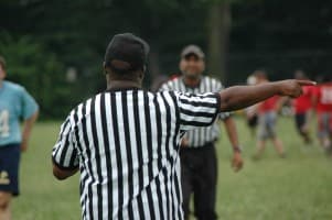 Referee signaling a first down while another official looks on