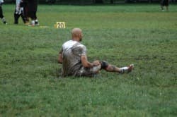 A mud-covered player sitting on the field at the 20-yard marker